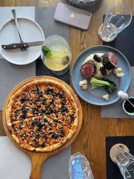 Overhead food flat-lay photography — pizza and plated steak dinner, restaurant brand content by byag.studio